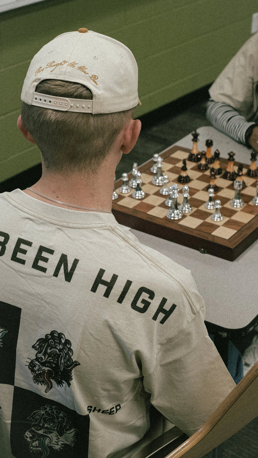 HAS/BEEN HIGH graphic tee back print on model playing chess lifestyle streetwear