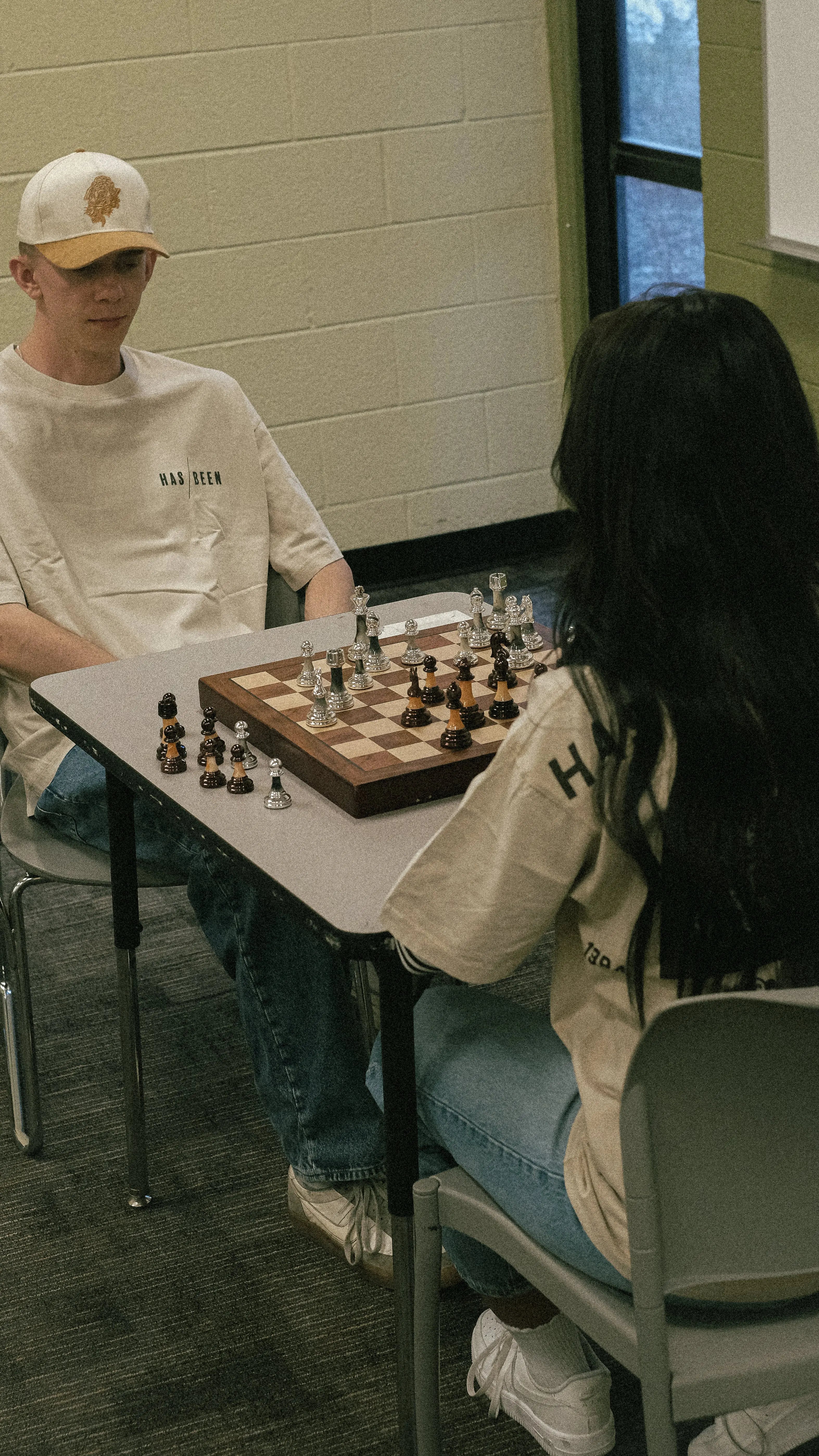HAS/BEEN HIGH streetwear tees on two models playing chess lifestyle scene